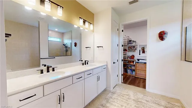 a en suite bathroom with double sink and a mirror