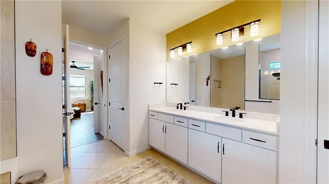 a bathroom with a double vanity sink mirror and shower