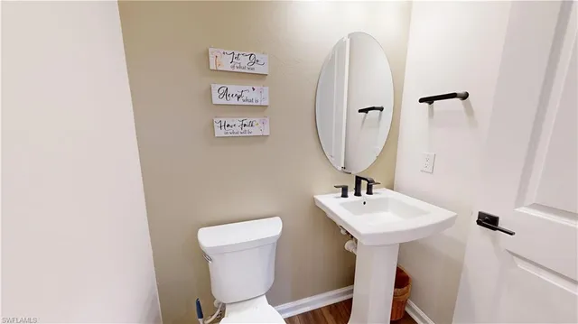 a bathroom with a sink mirror and toilet