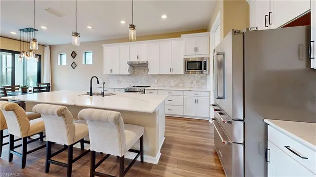 a large kitchen with a table chairs refrigerator and microwave