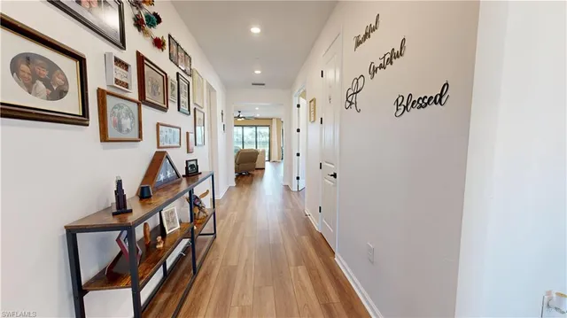 a view of a hallway with wooden floor and staircase