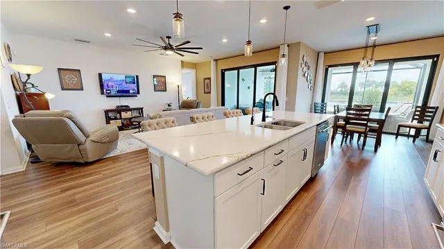 a large white kitchen with wooden floor a dining table and chairs