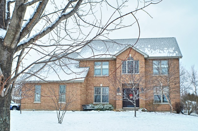 a front view of a house with a yard covered in snow