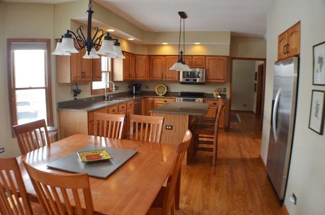 496 Lewis Road Geneva, IL 60134 - Photo 6 of 18 a kitchen with stainless steel appliances granite countertop a sink a stove a dining table and chairs