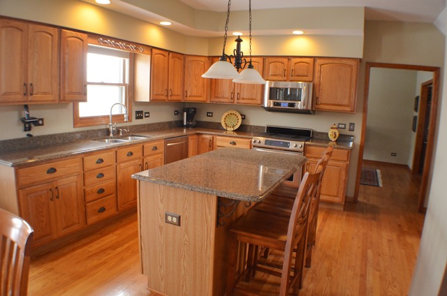 496 Lewis Road Geneva, IL 60134 - Photo 7 of 18 a kitchen with stainless steel appliances granite countertop a refrigerator a sink dishwasher a stove and a dining table with wooden floor