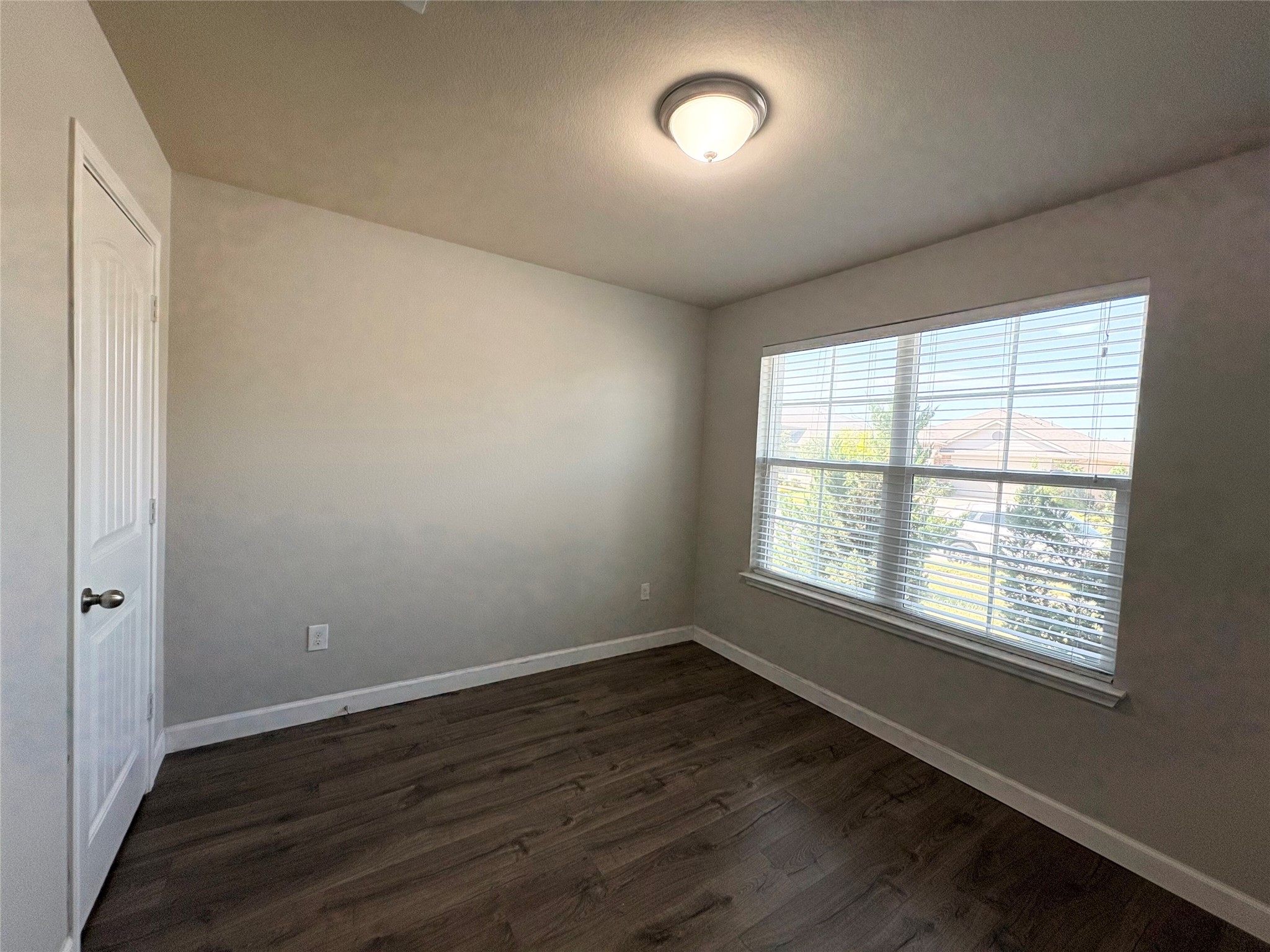 11708 Cambrian Road Manor, TX 78653 - Photo 16 of 31 An inviting room features rich wood flooring and a wide window, offering natural illumination.