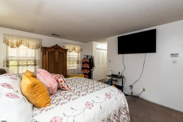 a bedroom with a bed a window and a flat screen television
