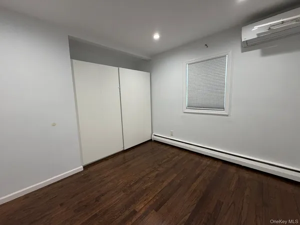 a view of small space with wooden floor and a window