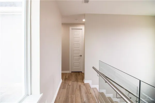an empty room with a ceiling fan and wooden floor