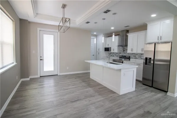 a kitchen with a refrigerator sink and cabinets