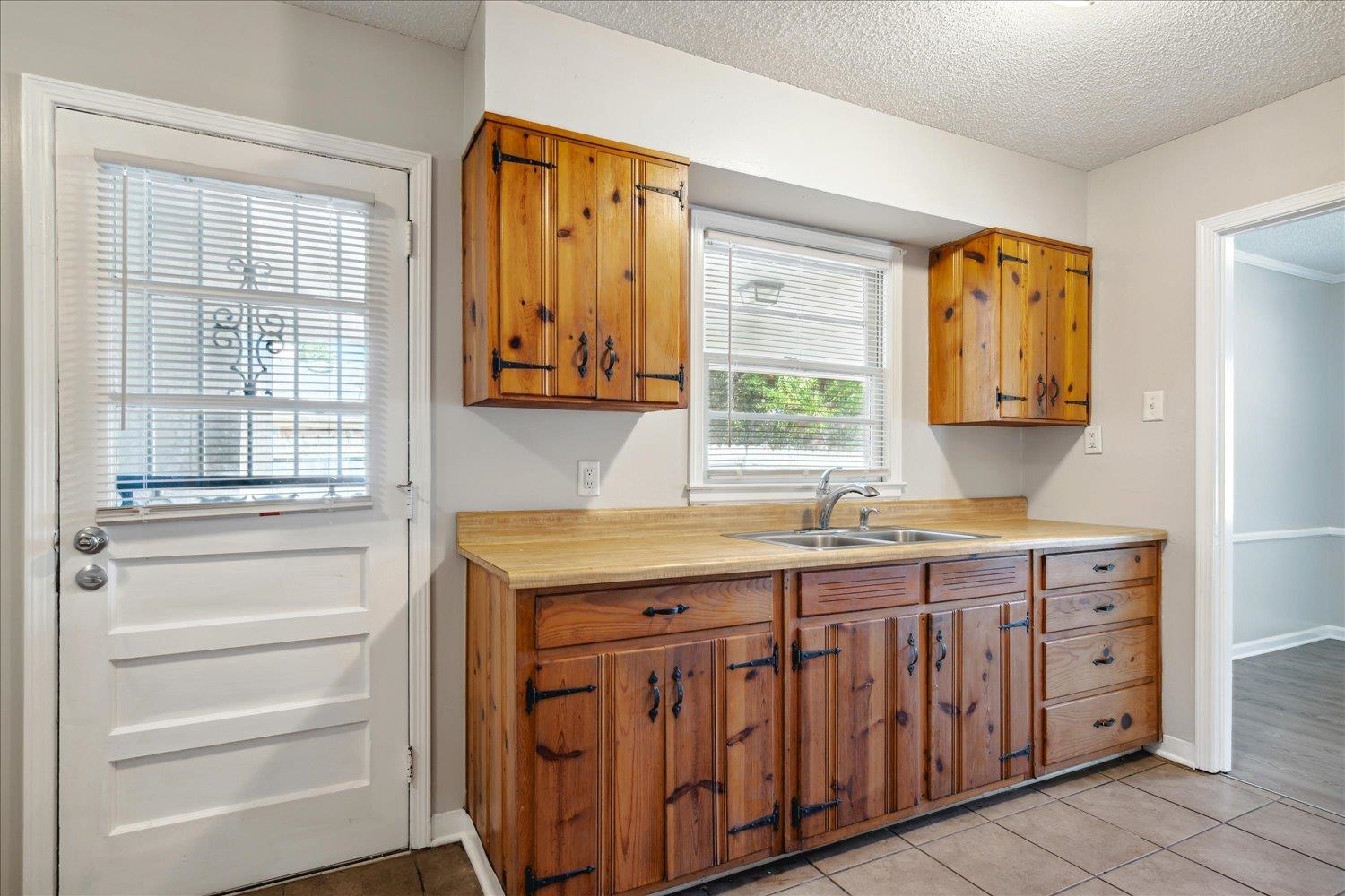 919 Stratford Road Memphis, TN 38122 - Photo 15 of 30 Kitchen featuring light tile patterned flooring, a textured ceiling, and sink