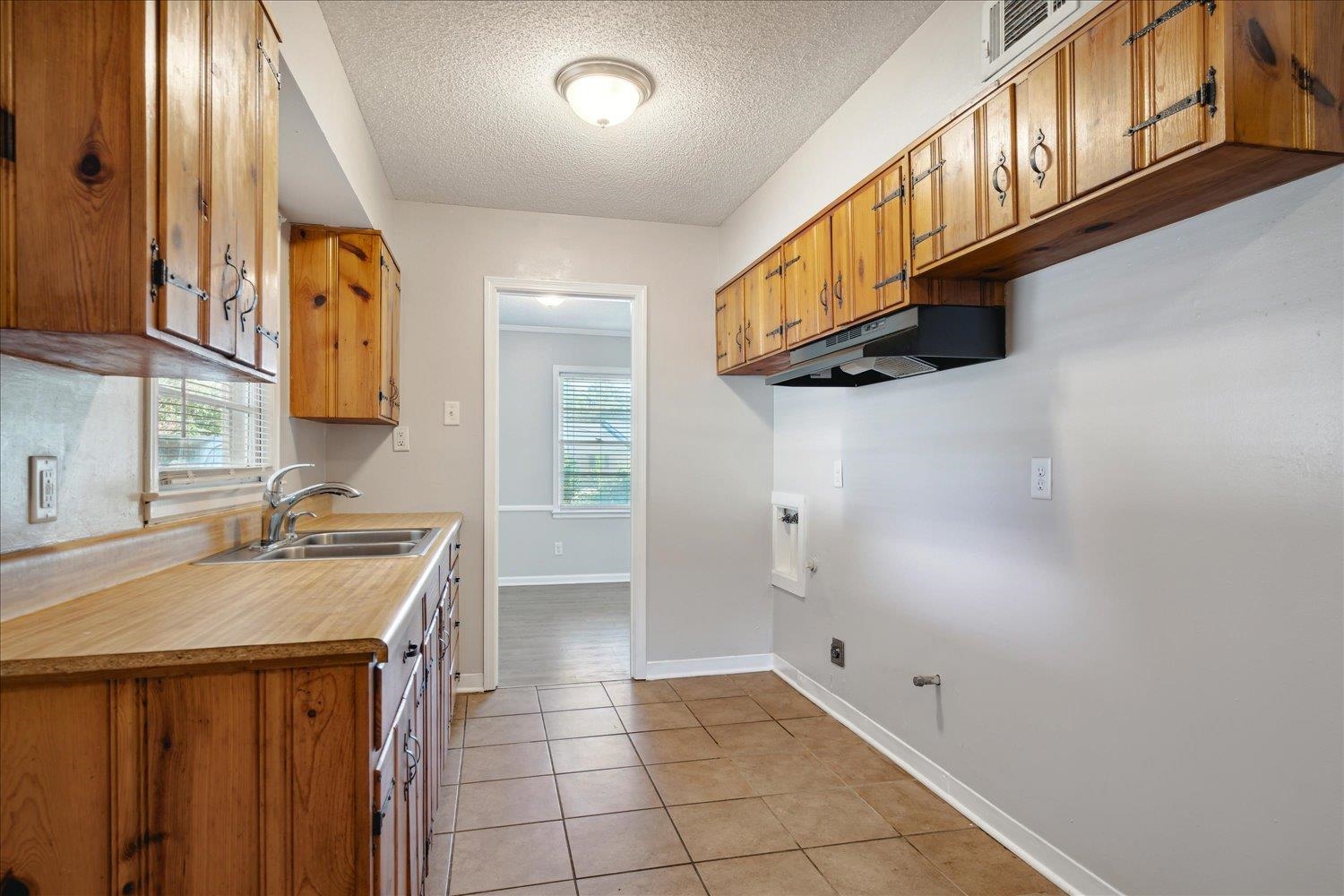 919 Stratford Road Memphis, TN 38122 - Photo 16 of 30 Kitchen featuring light tile patterned floors, a healthy amount of sunlight, a textured ceiling, and sink