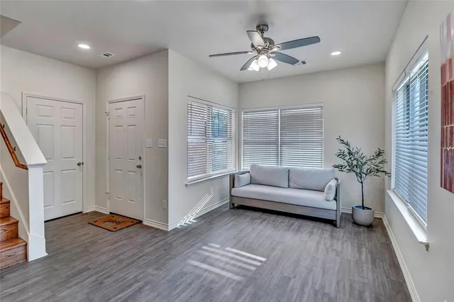 a room with stainless steel appliances kitchen island granite countertop a table chairs and a refrigerator