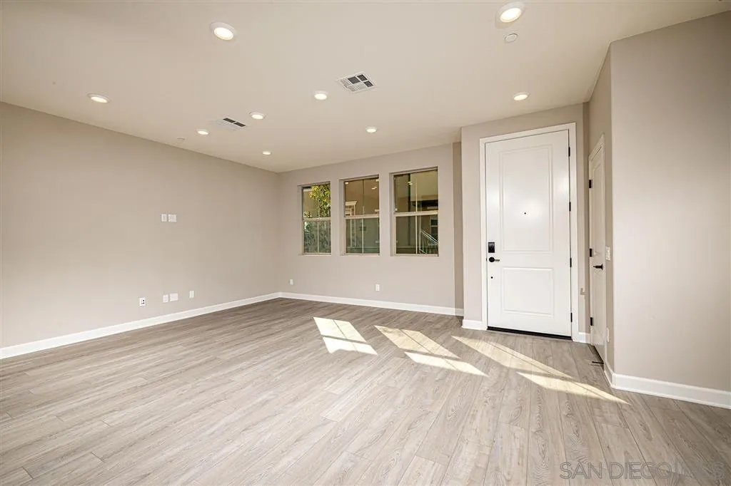 1182 Delpy View Point, Unit 106 Vista, CA 92084 - Photo 3 of 16 an empty room with wooden floor and windows