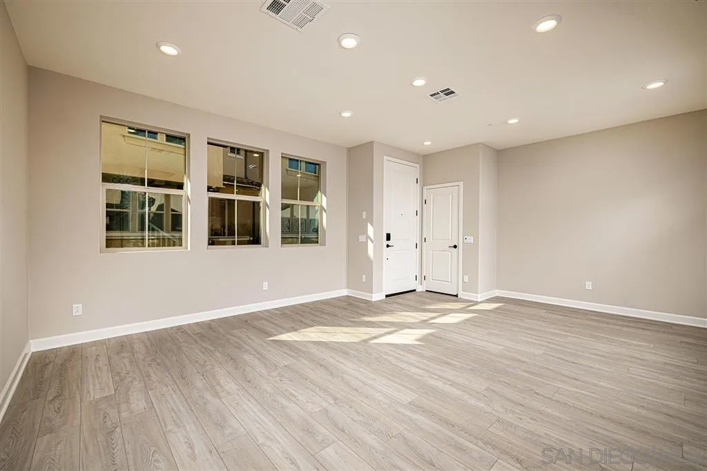 1182 Delpy View Point, Unit 106 Vista, CA 92084 - Photo 4 of 16 a view of empty room with wooden floor and windows