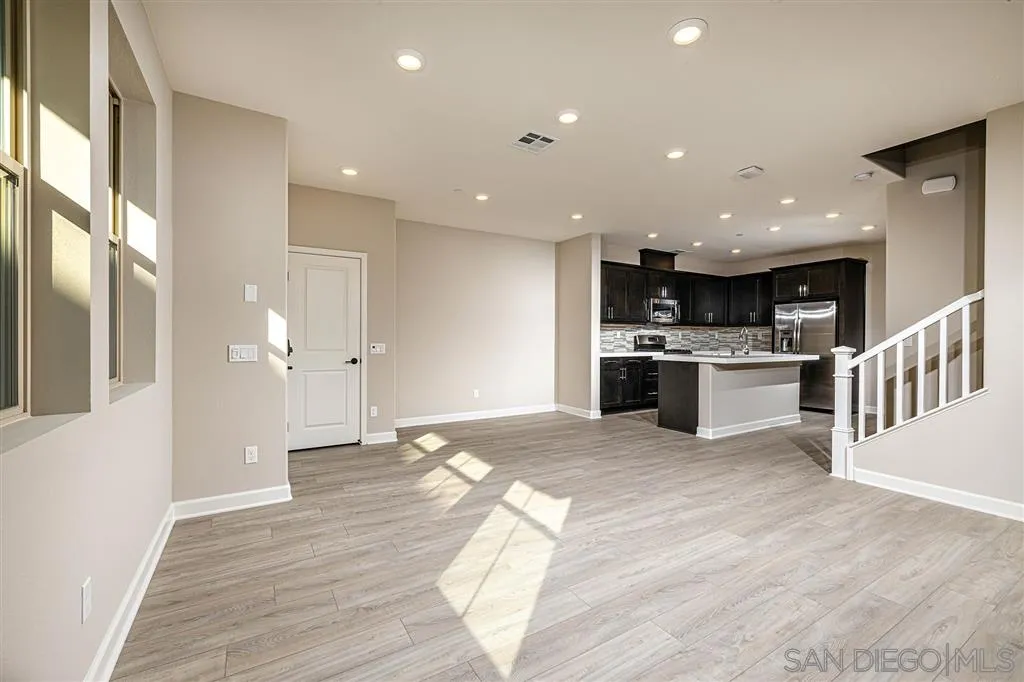 1182 Delpy View Point, Unit 106 Vista, CA 92084 - Photo 5 of 16 a view of a kitchen with a sink and dishwasher a refrigerator with wooden floor