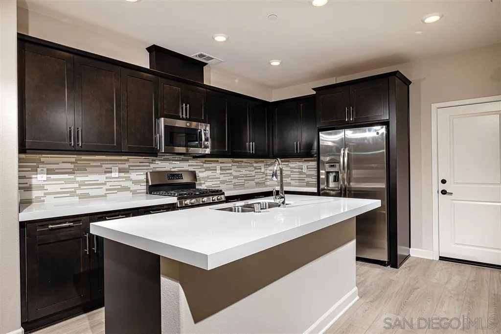 1182 Delpy View Point, Unit 106 Vista, CA 92084 - Photo 6 of 16 a kitchen with kitchen island a sink stove and refrigerator
