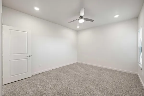an empty room with a chandelier fan