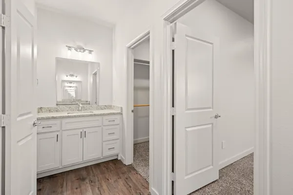 a bathroom with a granite countertop sink two mirror and a