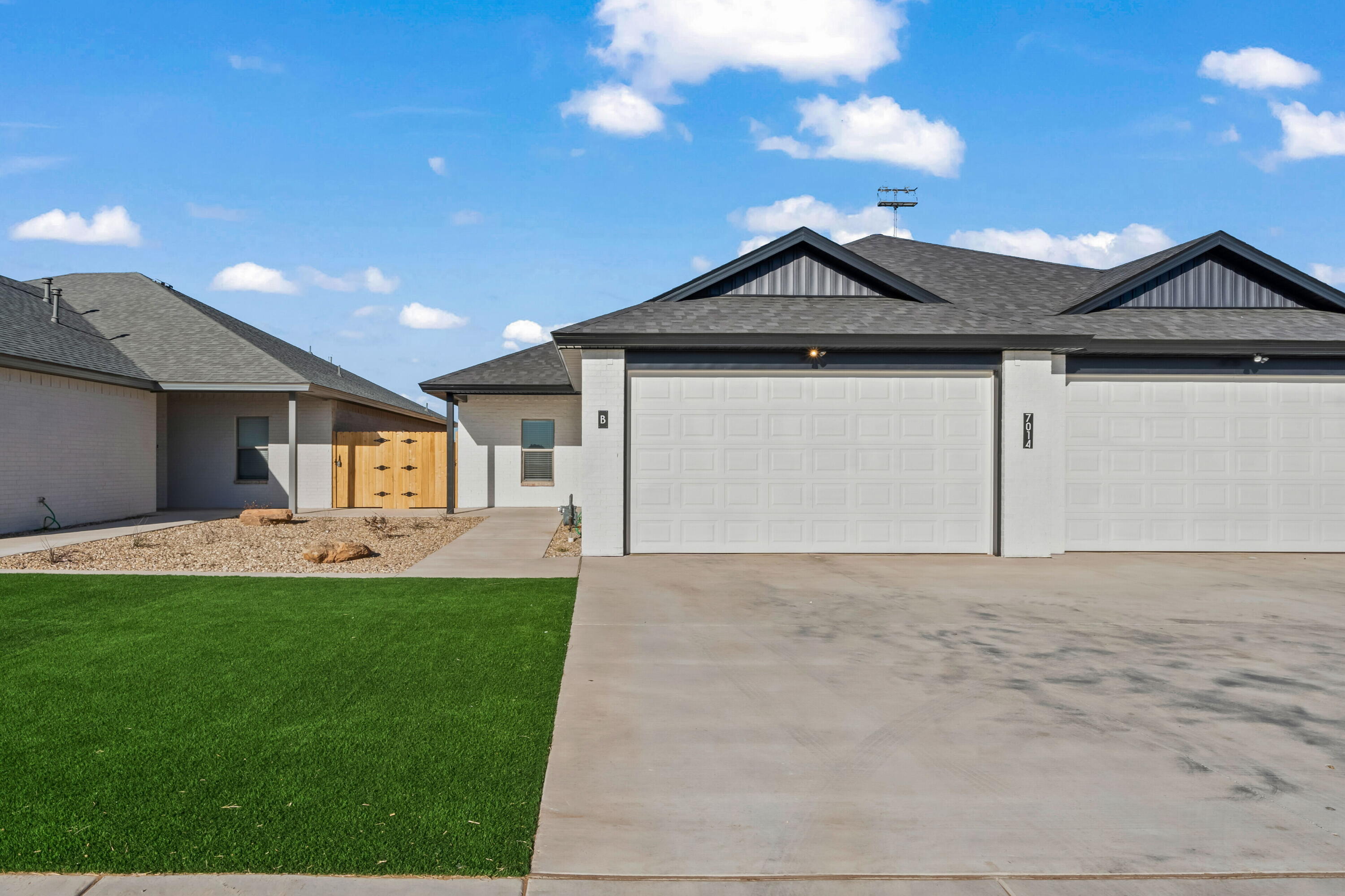 7014 40th Street, Unit B Lubbock, TX 79407 - Photo 2 of 20 a front view of a house with a yard and garage