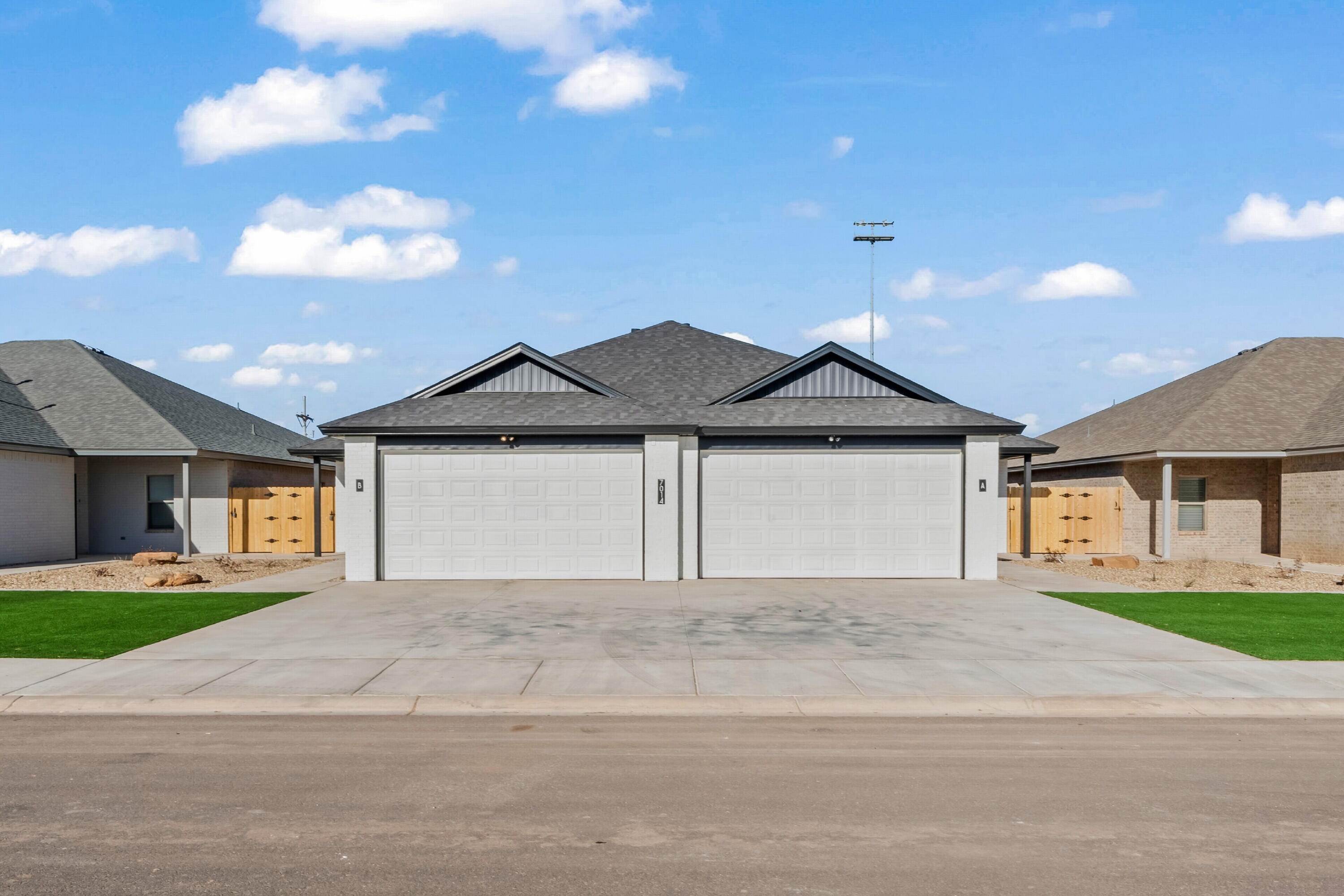 7014 40th Street, Unit B Lubbock, TX 79407 - Photo 3 of 20 a front view of a house with a yard and garage