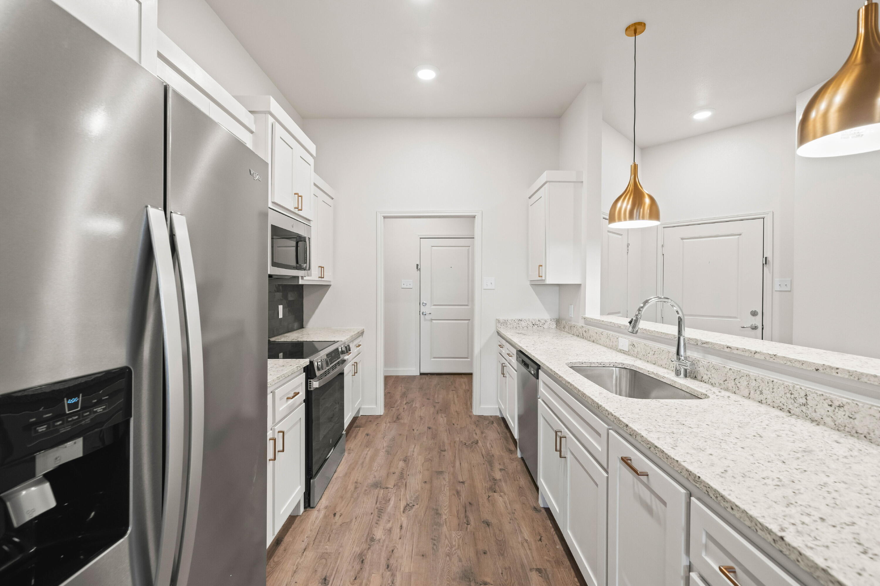 7014 40th Street, Unit B Lubbock, TX 79407 - Photo 9 of 20 a kitchen with stainless steel appliances granite countertop a sink a stove and a refrigerator