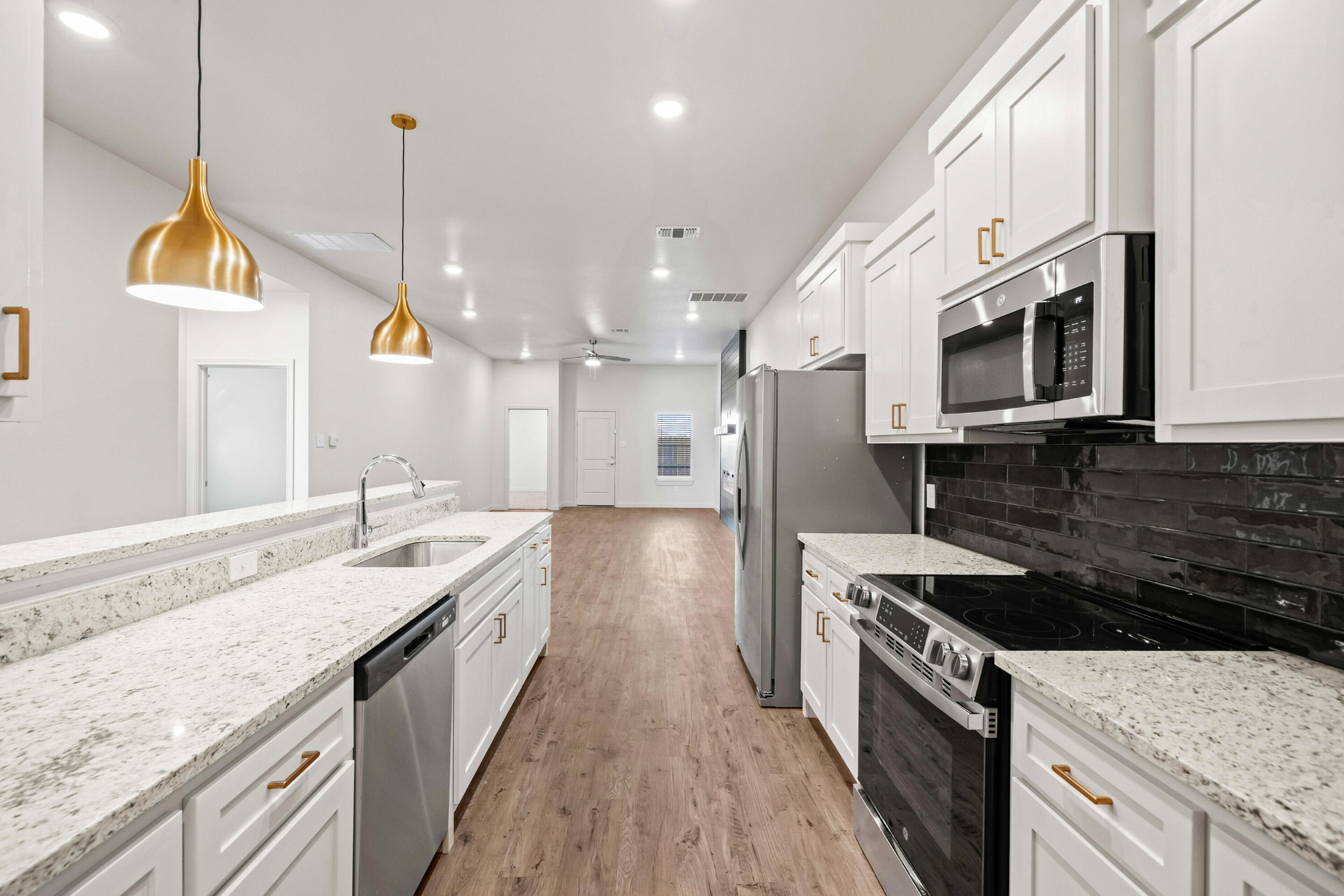 7014 40th Street, Unit B Lubbock, TX 79407 - Photo 10 of 20 a large kitchen with stainless steel appliances granite countertop a stove a sink and a microwave