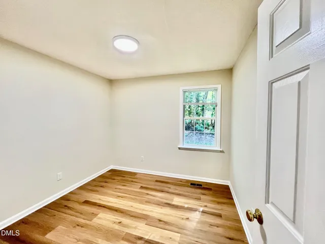 a view of a room with a window and wooden floor