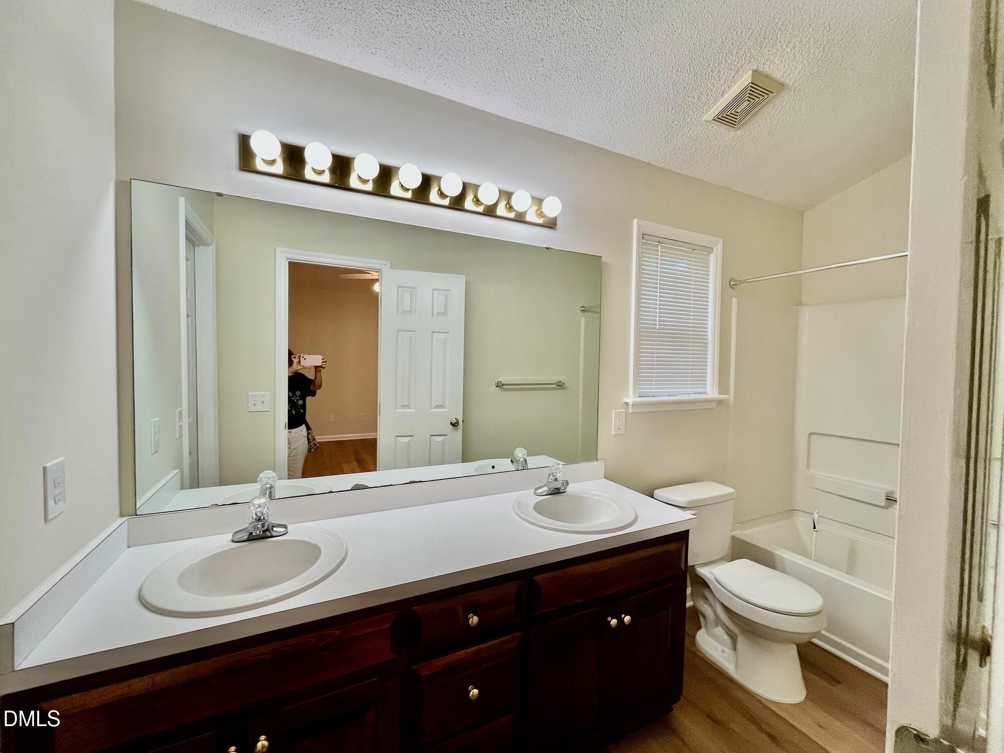 5413 Passenger Place Raleigh, NC 27603 - Photo 10 of 16 a bathroom with a double vanity sink toilet and a mirror