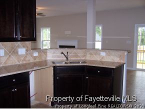 712 Sun Road Aberdeen, NC 28315 - Photo 5 of 6 a kitchen with granite countertop a sink and cabinets