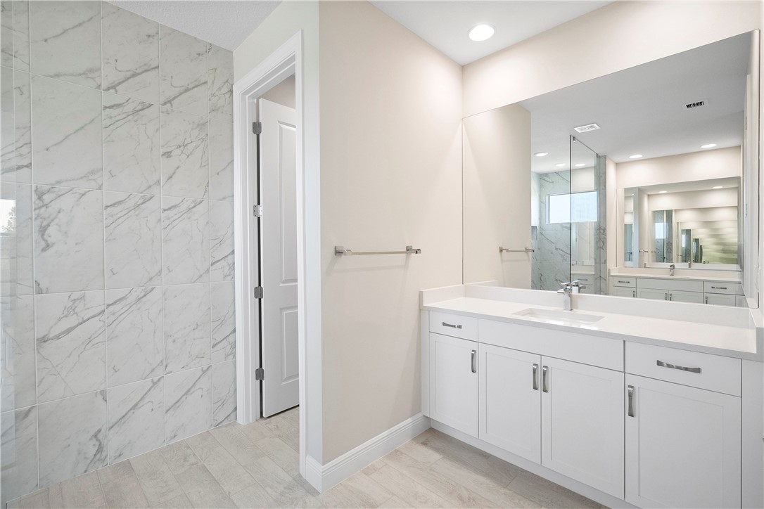 6344 High Pointe Circle Vero Beach, FL 32967 - Photo 16 of 26 a bathroom with a granite countertop sink a mirror and a shower