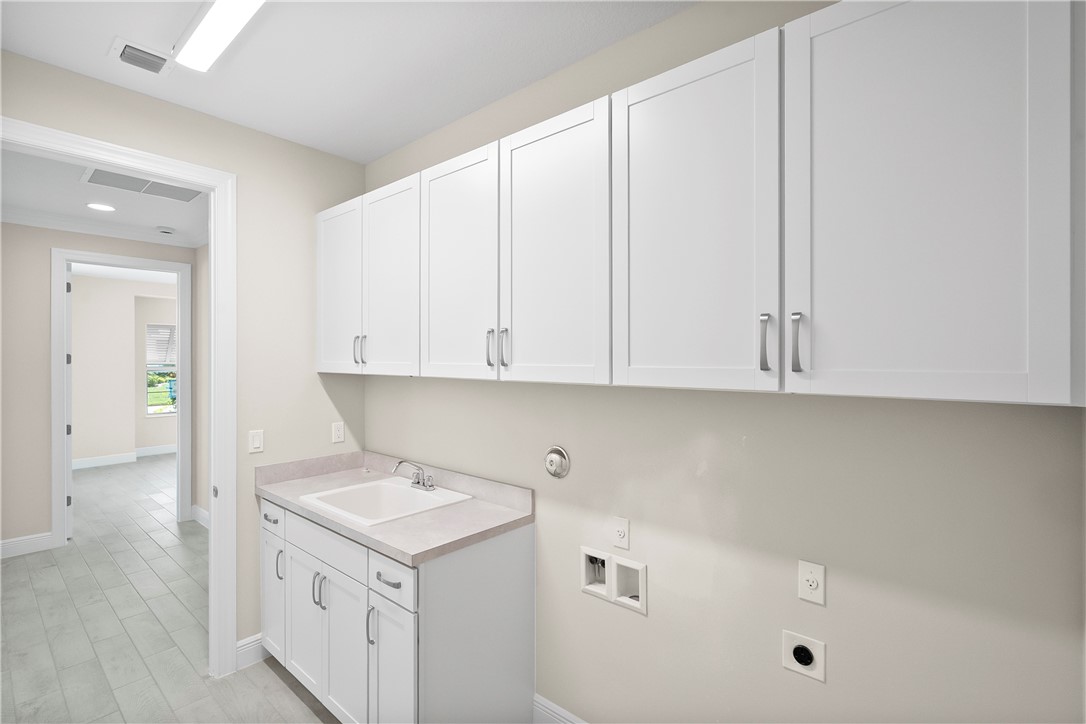 6344 High Pointe Circle Vero Beach, FL 32967 - Photo 19 of 26 a utility room with cabinets washer and dryer