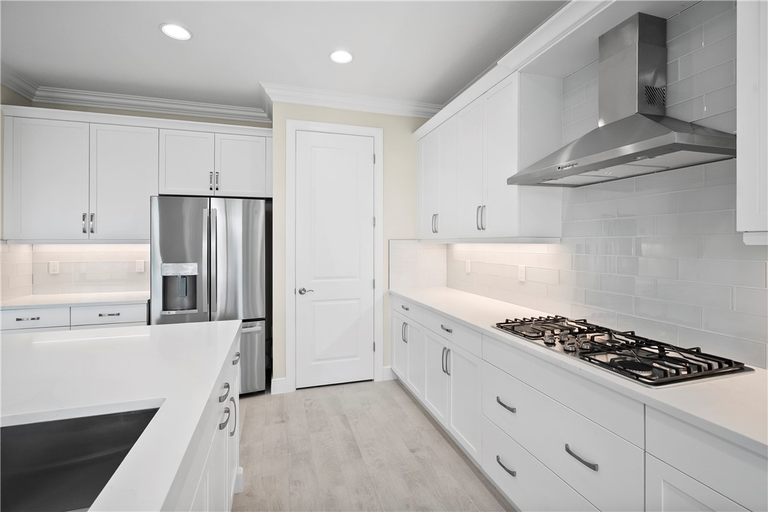 6344 High Pointe Circle Vero Beach, FL 32967 - Photo 5 of 26 a kitchen with stainless steel appliances a refrigerator a stove and white cabinets