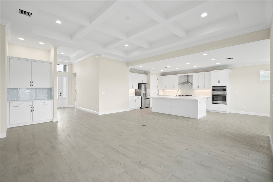 6344 High Pointe Circle Vero Beach, FL 32967 - Photo 10 of 26 a view of a kitchen with a sink and dishwasher a refrigerator with white cabinets