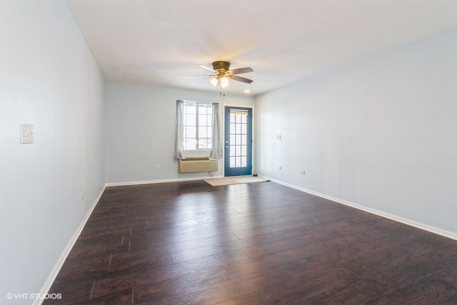 1441 McClure Road, Unit 1441 Aurora, IL 60505 - Photo 3 of 10 an empty room with windows and ceiling fan