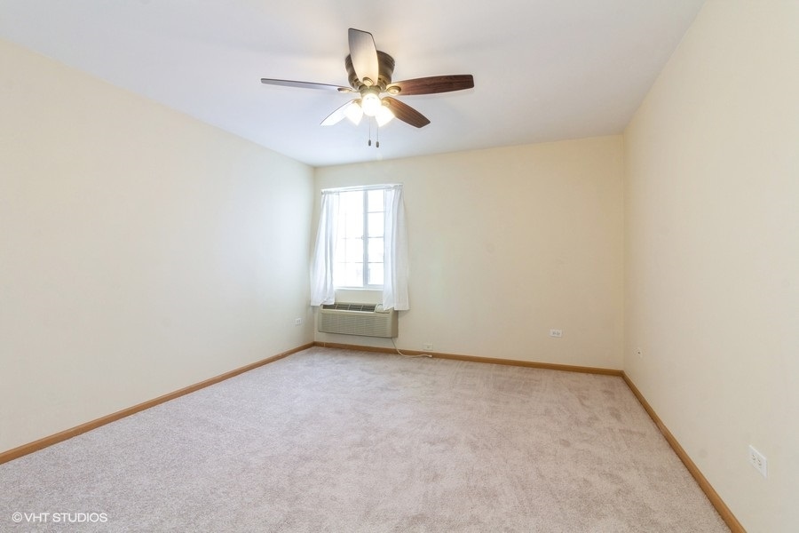 1441 McClure Road, Unit 1441 Aurora, IL 60505 - Photo 7 of 10 an empty room with a window and a ceiling fan