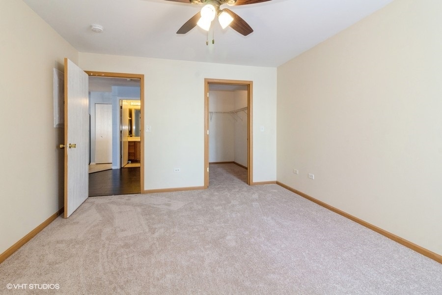 1441 McClure Road, Unit 1441 Aurora, IL 60505 - Photo 8 of 10 an empty room with closet and a chandelier fan