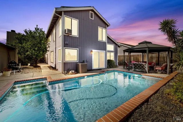 a view of a house with swimming pool and sitting area