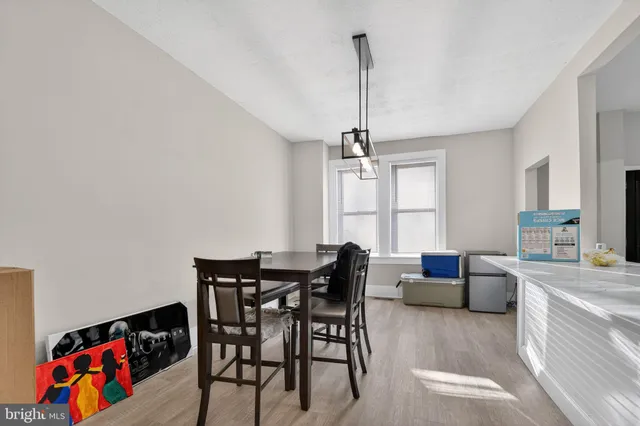 a view of a dining room and livingroom with furniture wooden floor a chandelier