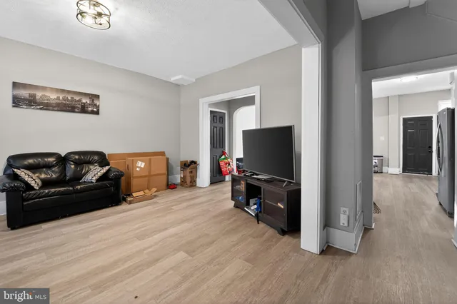 a living room with furniture a flat screen tv and a window