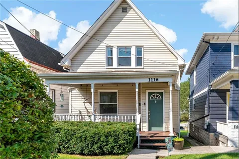 a view of a brick house with potted plants
