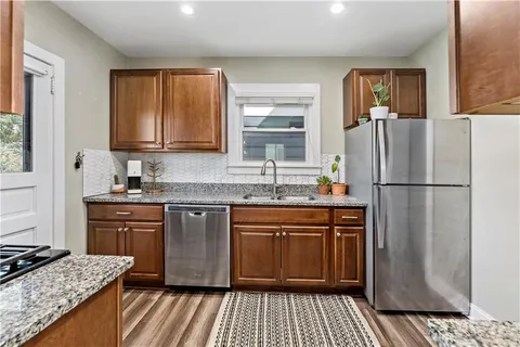 a kitchen with stainless steel appliances granite countertop a refrigerator stove sink and cabinets