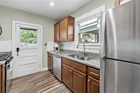 a kitchen with stainless steel appliances granite countertop a refrigerator and a sink