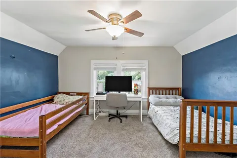 a bedroom with furniture and a ceiling fan