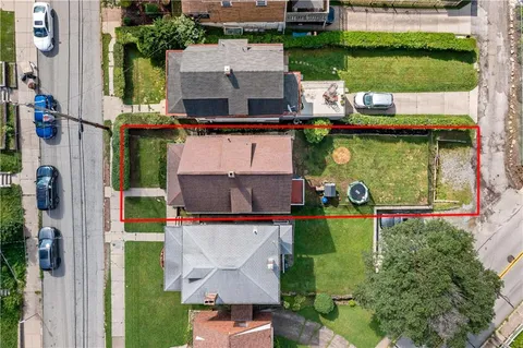 an aerial view of residential houses with outdoor space and lake view