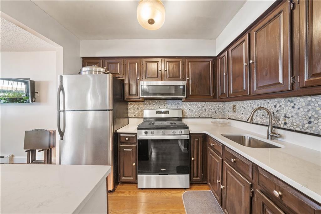 888 Gates Avenue Brooklyn, NY 11221 - Photo 6 of 18 a kitchen with a sink stove and refrigerator