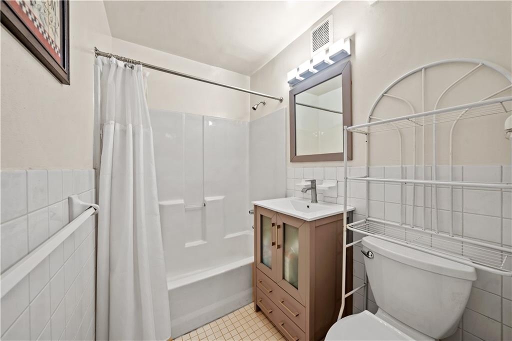 888 Gates Avenue Brooklyn, NY 11221 - Photo 10 of 18 a bathroom with a granite countertop sink toilet and shower