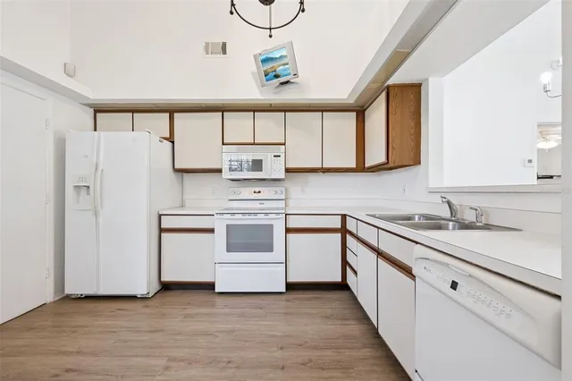 a kitchen with white cabinets and white appliances