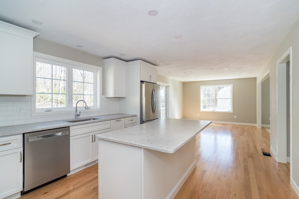 41 Martin Road Douglas, MA 01516 - Photo 12 of 32 a kitchen with granite countertop a sink cabinets wooden floor and stainless steel appliances