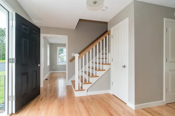 a view of front door with wooden floor and stairs